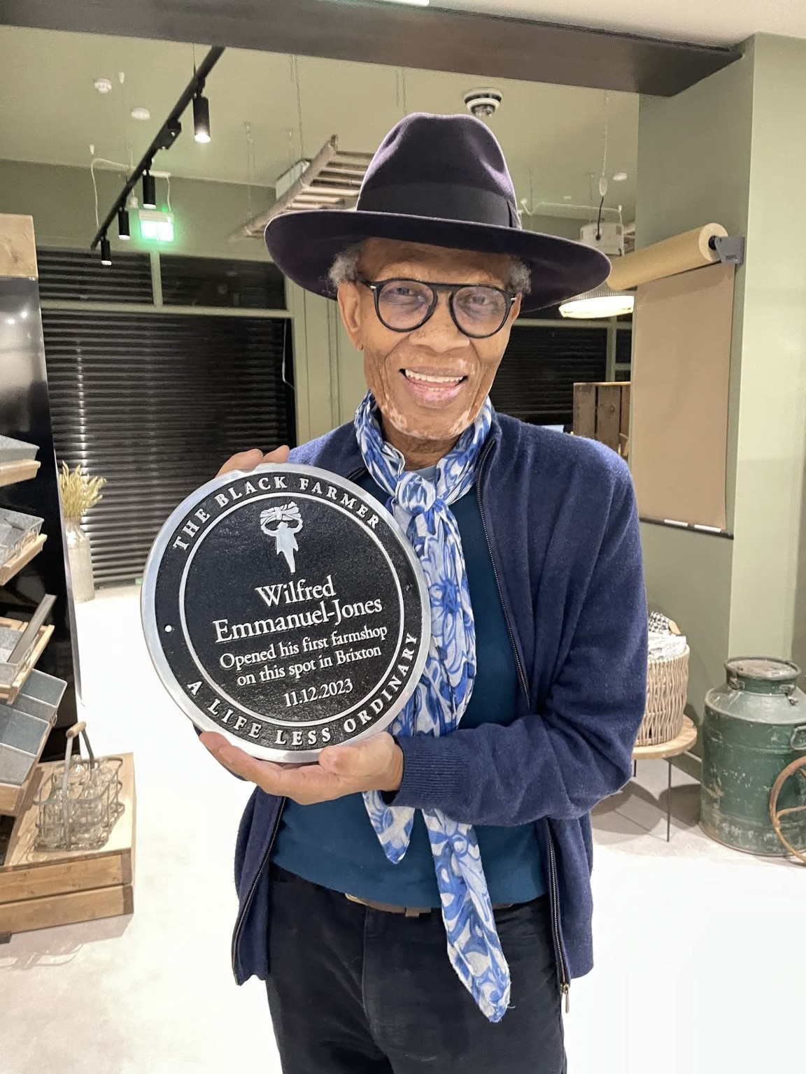 Wilfred Emmanuel-Jones holding his Brixton farmshop plaque